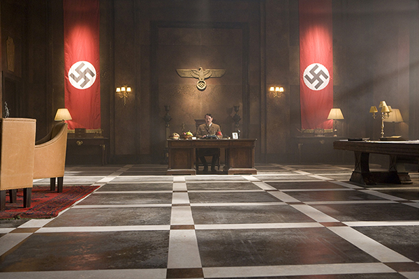 Adolf Hitler (Albert Welling) at the desk in vast office