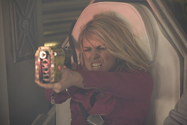 Rose (Billie Piper) raises weapon, hair blowing, sat in seat
